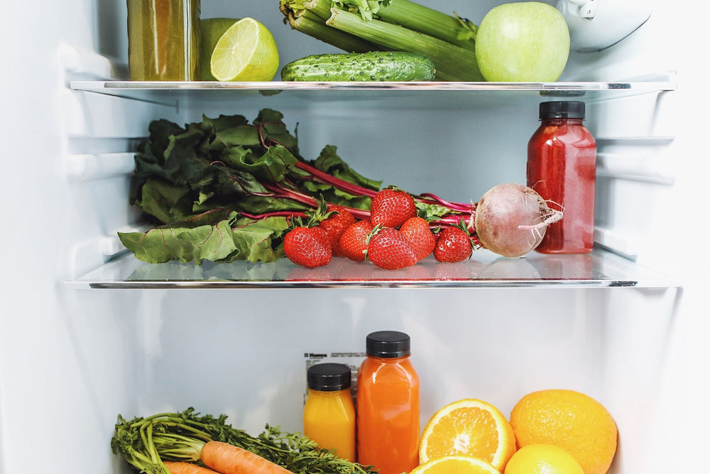 Fresh vegetables, herbs and fruit stored neatly on fridge shelves