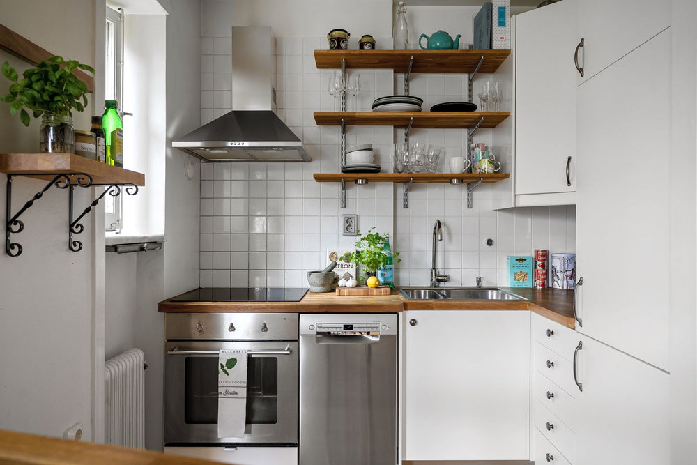 A small, tidy kitchen with open shelves, a clear counter and organized cupboards